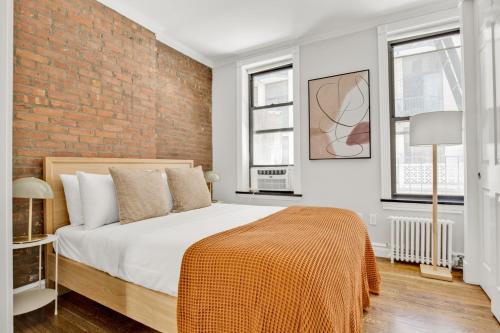 a bedroom with a bed and a brick wall at Kips Bay 1BR w WD nr E River 6 Train NYC-829 in New York