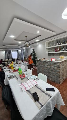 een eetkamer met een lange tafel met witte tafellaken bij Suprime Hotels and Conference in Pietermaritzburg