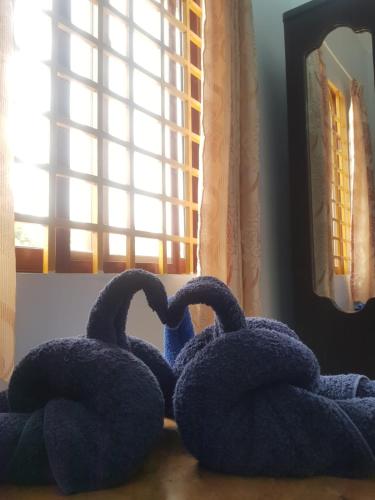 two towels shaped like swans sitting on a table at Bloom Garden Bed & Breakfast in Siem Reap