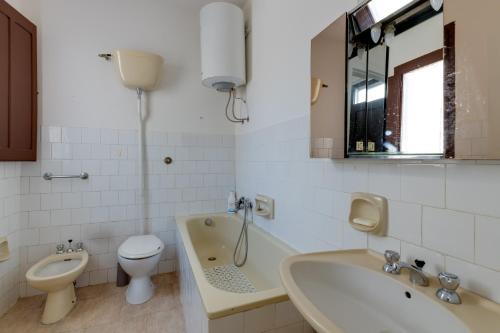 e bagno con servizi igienici, lavandino e vasca. di Casa vacanze Ghilarza Sardegna a Ghilarza