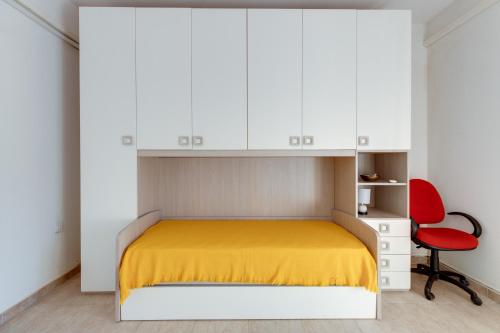 una camera con letto e sedia rossa di Casa vacanze Ghilarza Sardegna a Ghilarza
