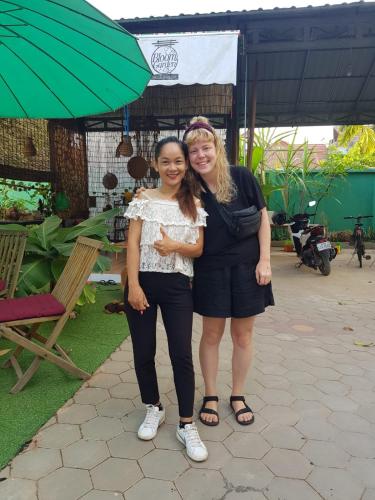 two women posing for a picture under an umbrella at Bloom Garden Bed & Breakfast in Siem Reap