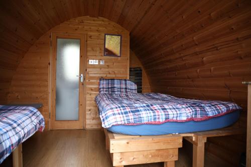 a room with two beds in a log cabin at Clovullin Croftview Pod in Ardgour