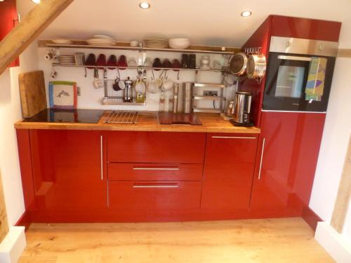 a kitchen with a wooden counter and a refrigerator at Prestwick House - Sleeps 10+ - Main House & 3 Separate Oak Framed Barn Studios - Rural in Chiddingfold