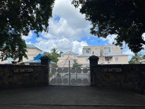 a fence with a gate in front of a house at Your west coast getaway in Flic-en-Flac
