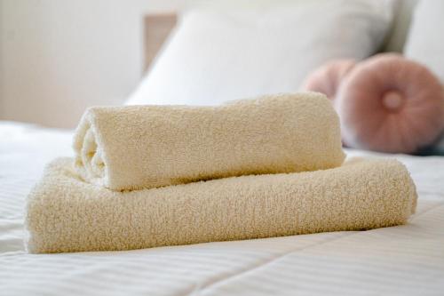 a stack of towels sitting on top of a bed at Apartmaji Pr' Kopavank in Rateče