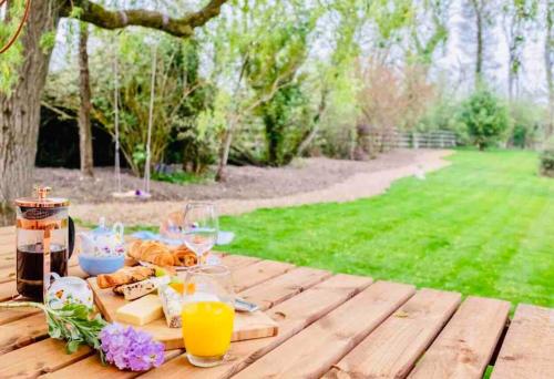 a picnic table with orange juice and bread and drinks at The Retreat in Lymington