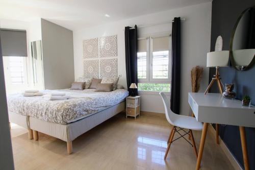 1 dormitorio con cama, mesa y escritorio en TESS Villa Jocalo, en Alhaurín de la Torre