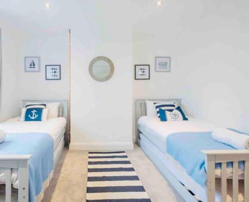 dwa łóżka w pokoju niebiesko-białym w obiekcie The Retreat w mieście Lymington