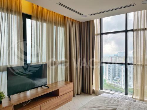 a bedroom with a flat screen tv in front of a window at Lovely 3-bedrooms with Karaoke Genting Penthouse in Genting Highlands