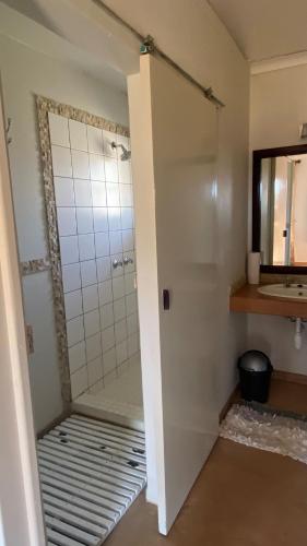a bathroom with a shower stall and a mirror at Out Of Nature Country Lodge in Windhoek