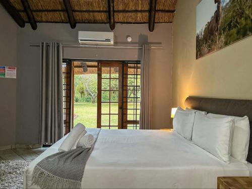 um quarto com uma grande cama branca e uma janela em 63 On Nyala, Lodge venue & conference em Stil Gelee