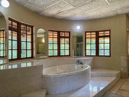 uma grande casa de banho com uma grande banheira e janelas em 63 On Nyala, Lodge venue & conference em Stil Gelee
