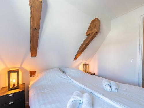 a bedroom with a bed with white sheets and wooden crosses at Modern renovated apartment in the heart of Sneek in Sneek