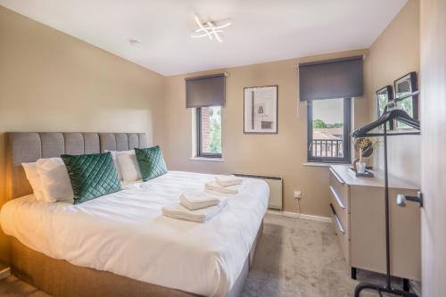 1 dormitorio con 1 cama con toallas en Waterlily Apartment - Beautiful 1-bed with overlooking balcony, en Nottingham