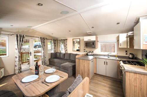 a kitchen and living room in a caravan with a table at St. Ives Holiday Village in St Ives