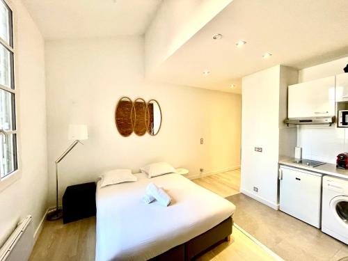 une chambre blanche avec un lit dans une cuisine dans l'établissement Le Caboteur - Studio proche Place de la Daurade, à Toulouse