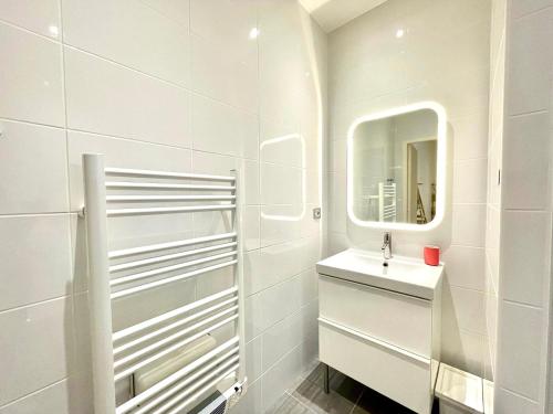 une salle de bain blanche avec un lavabo et un miroir dans l'établissement Le Caboteur - Studio proche Place de la Daurade, à Toulouse