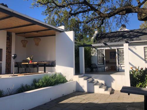 a white house with a patio and a table at Tempel Wines in Paarl