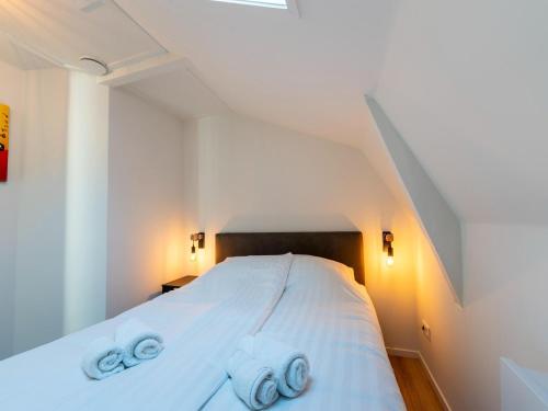 een slaapkamer met een wit bed en 2 handdoeken bij Cozy apartment in the heart of Sneek in Sneek