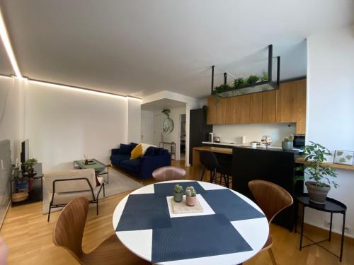 Il comprend un salon et une cuisine avec une table et des chaises. dans l'établissement L'Eclatant - Au cœur de Toulouse, à Toulouse