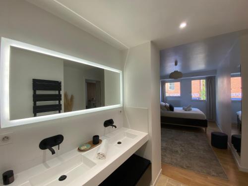 une salle de bain avec un lavabo blanc et un miroir dans l'établissement L'Eclatant - Au cœur de Toulouse, à Toulouse