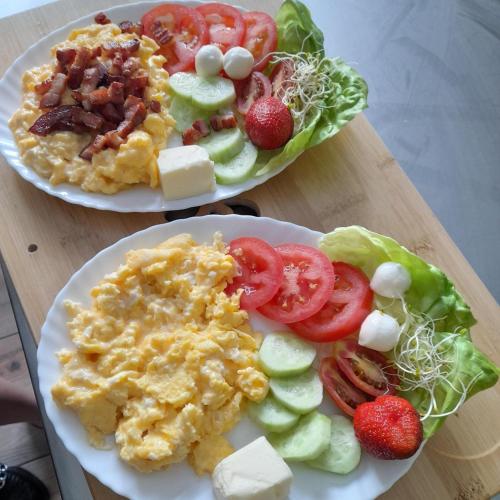 two plates of breakfast food on a wooden table at Gazdówka na Mosornym Groniu in Zawoja