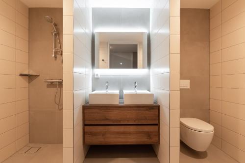a bathroom with two sinks and a toilet at BizStay Walden in The Hague