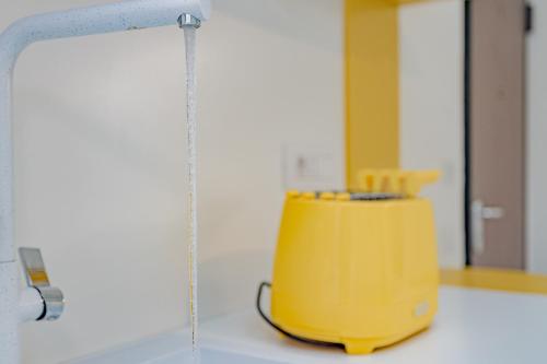 un exprimidor amarillo sentado en la parte superior de un mostrador en MILAN MCHOME en Trezzano sul Naviglio
