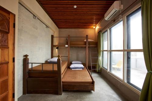 two bunk beds in a room with a window at Untapped Hostel in Sapporo