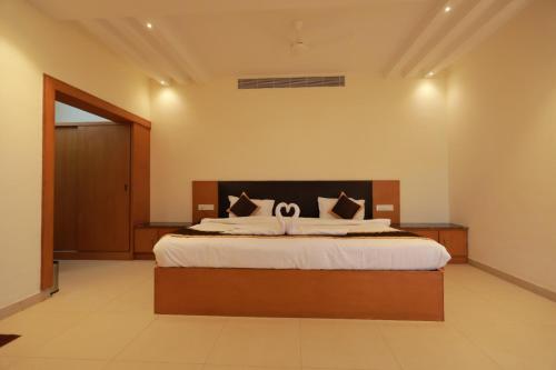 a bedroom with a large bed in a room at Hotel Ashok Palace in Karūr