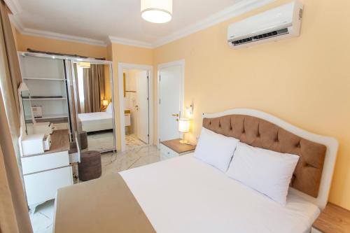 um quarto com uma cama branca e um espelho em Yellow Villa em Muğla