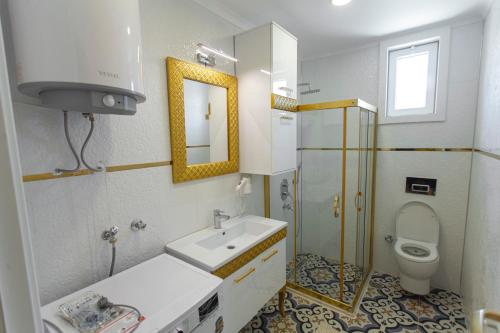 uma casa de banho com um lavatório, um WC e um espelho. em Yellow Villa em Muğla