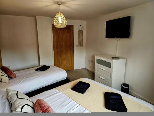 Habitación de hotel con 2 camas y TV en Homebird Property - Epsom Apartment en Harrogate