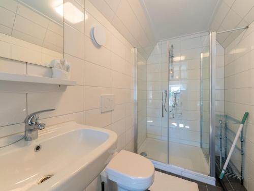 een badkamer met een douche, een toilet en een wastafel bij Modern renovated apartment in the heart of Sneek in Sneek