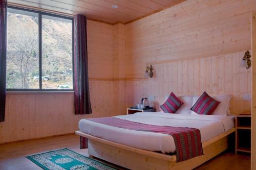1 dormitorio con 1 cama en una habitación de madera en Keerong Cottages Lachung, en Lachung