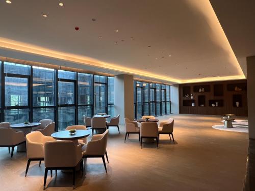 台州的住宿－台州开投华美达酒店，餐厅设有桌椅和窗户。