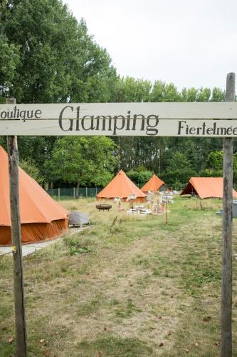 ein Zeichen für eine Gruppe von Zelten auf einem Feld in der Unterkunft Fiertelmeers Boutique Glamping in Ronse