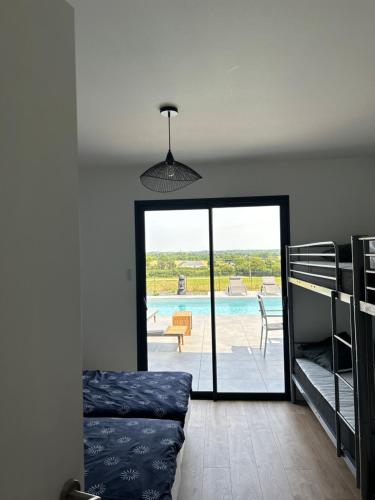 a bedroom with a bed and a view of a pool at Villa de Groupe avec Piscine, Jacuzzi et Vue Nature in Pierric