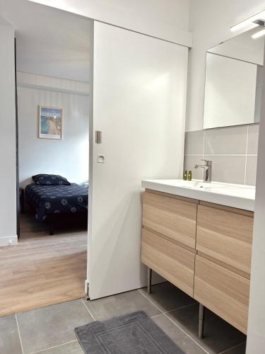 a bathroom with a sink and a mirror and a bed at Villa de Groupe avec Piscine, Jacuzzi et Vue Nature in Pierric