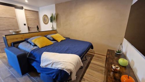 a bedroom with a bed with blue sheets and yellow pillows at Cocooning LE MUGEL aux portes des calanques de Cassis & SPA in Carnoux