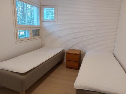 2 Betten in einem Zimmer mit 2 Fenstern in der Unterkunft Merimaisema 6 in Kalajoki