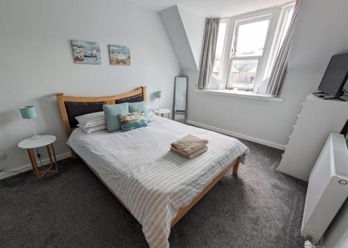 a bedroom with a bed and a television in it at 2 Bedroom Townhouse on NC500, Wick, Highland in Wick