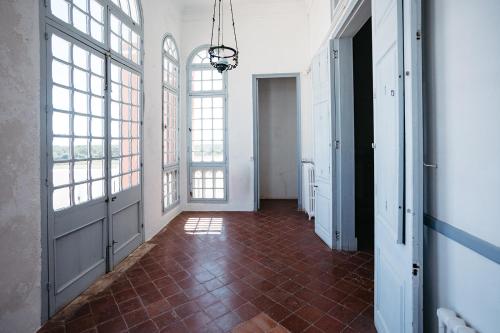 an empty hallway with windows and a red tile floor at Agroturismo Son Triay in Ferreries