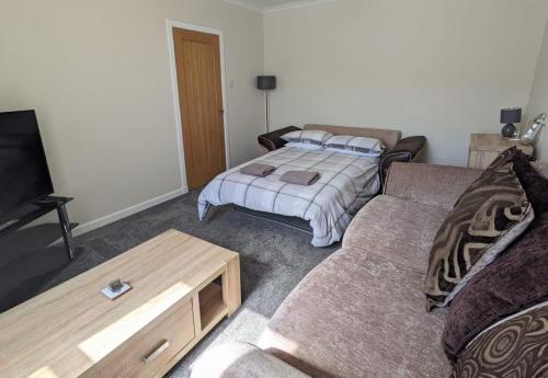 a living room with a couch and a bed at 2 Bedroom Townhouse on NC500, Wick, Highland in Wick