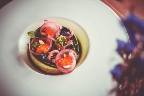 a bowl of food with tomatoes and other vegetables at Hotel Alpenkönig in Oberstaufen