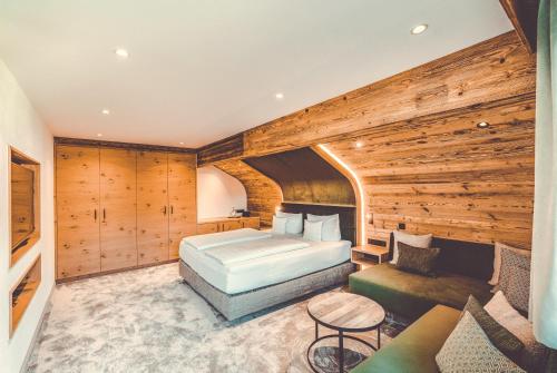 a bedroom with a bed and a couch in a room at Hotel Alpenkönig in Oberstaufen