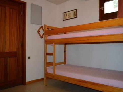 Ce dortoir comprend 2 lits superposés et une porte. dans l'établissement Charmant T2 Cabine avec balcon et parking à Font-Romeu - FR-1-580-12, à Font-Romeu-Odeillo-Via