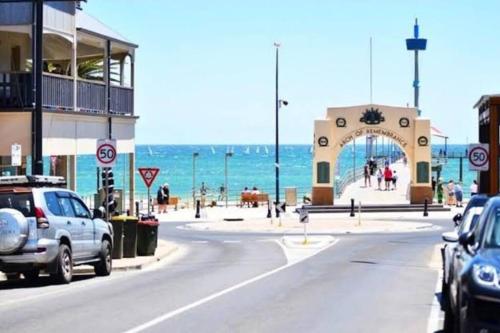 a street with cars parked on a road next to the ocean at Seaside Villa Steps to Beach, Cafes, Boutiques in Brighton
