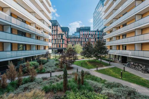 an apartment building with a garden in a city at Pure Rental Apartments in Wrocław